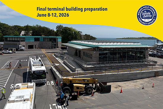 A construction vehicle and buses are parked near a modern terminal building under construction by the water, with a project update banner overhead.